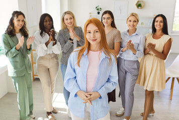Women leadership team meeting in office. A confident portrait shows a young female leader as colleagues applaud, highlighting strategy, training, and teamwork. Core idea teamwork, business success.