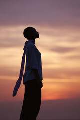 determined woman holds sporty ribbon against stunning sunset backdrop