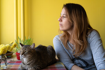 A woman with her cat friend at the table in the morning