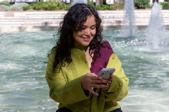 Gen Z woman enjoying urban lifestyle near fountain