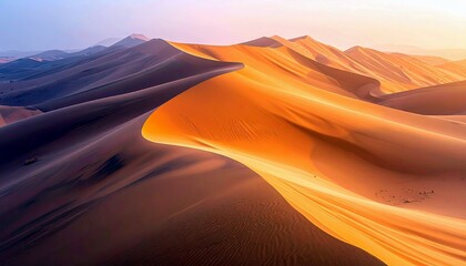 Vast desert landscape with undulating sand dunes bathed in the warm glow of sunrise, casting long shadows.