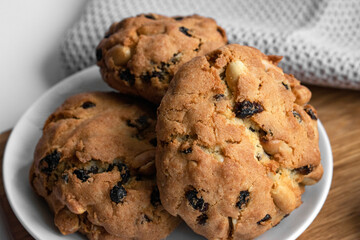 Close up photo homemade cookies with nuts and raisins on a white plate. For bakery recipes, food posts, articles about food and other.