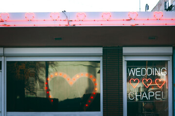 Neon-lit wedding chapel exterior with glowing hearts