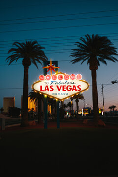 Las Vegas welcome sign at dusk with palm trees