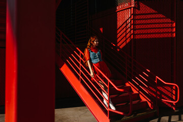 Woman on vibrant staircase with striking shadows