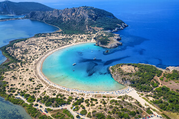 Aerial view of the half circle shaped Voidokilia beach in Messinia, Peloponnese, Greece, with sand dunes and turquoise sea