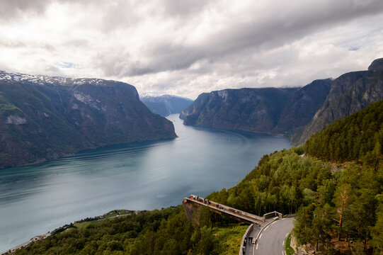Aerial view of the Stegastein viewpoint jutting out over the Aurlandsfjord with the mountains reflecting in the water, Aurland, Vestland, Norway.