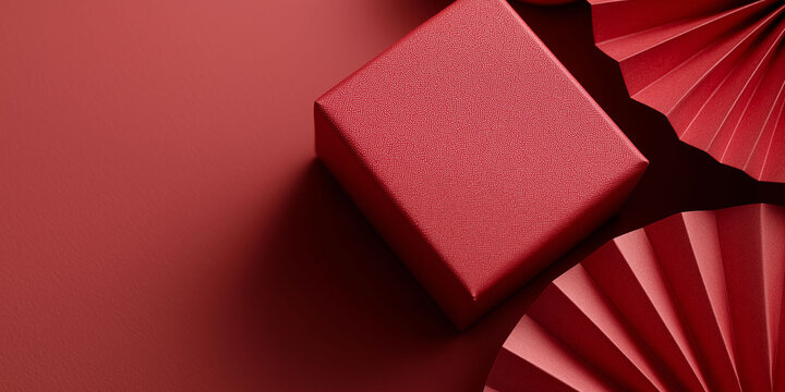 Elegant red fan beside beautifully wrapped gifts with traditional Asian patterns.
