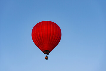 Red hot air balloon in the sky. Beautiful balloon against a blue sky.