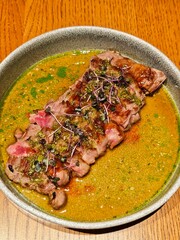 Juicy grilled steak with herbs and sauce served in bowl. Hugh-quality gourmet meal photo ideal for restaurant menus, advertising, or premium food branding. 