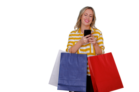 Happy young woman holding shopping bags and smartphone, shopping online or texting, enjoying retail experience, transparent background