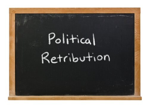 Political retribution written in white chalk on a black chalkboard isolated in a wooden frame