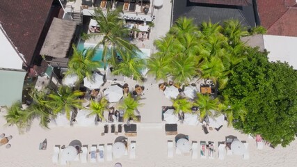 Overhead drone clip showing sun loungers and poolside area at luxury holiday resort
