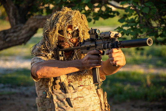 Man in camouflage aims rifle during airsoft skirmish