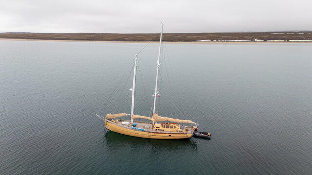 Yellow sailboat anchored off Disko Island in Greenland