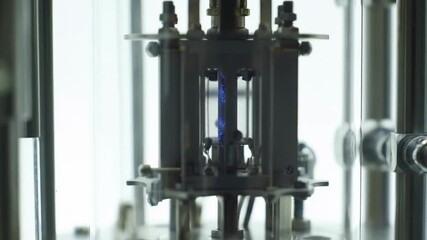 Close up of a plasma chamber with blue plasma inside for scientific research