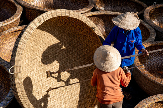Aerial view of workers wearing traditional hats, surrounded by woven baskets, the textures and shadows create a captivating scene, Ho Chi Minh City, Ho Chi Minh City, Vietnam.