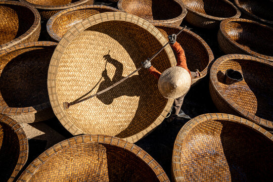 Aerial view of a craftsman amidst a sea of woven baskets, the warm hues and intricate textures painting a vibrant scene, Ho Chi Minh City, Ho Chi Minh City, Vietnam.
