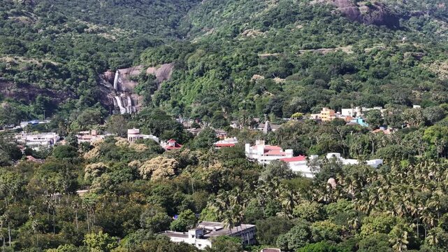 Scenic aerial panorama of Courtallam in Tenkasi, Tamil Nadu, featuring waterfalls, temple gopurams, palm groves, and rice fields near the Western Ghats.