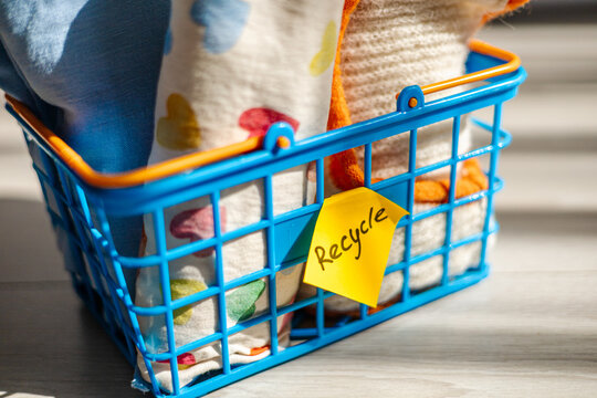 Recycle note on a blue basket with textiles inside