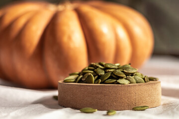 Pumpkin seeds with a large pumpkin in the background