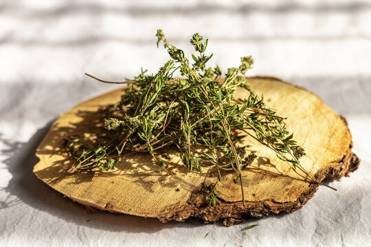 Fresh thyme herbs resting on a wooden slice surface