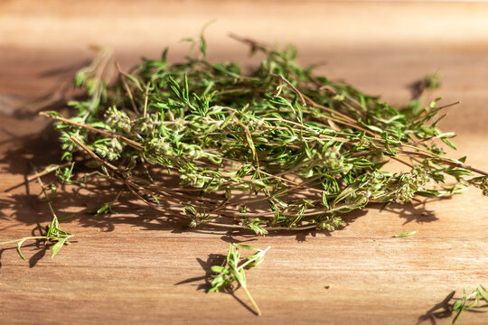Fresh thyme herbs on a wooden board in sunlight