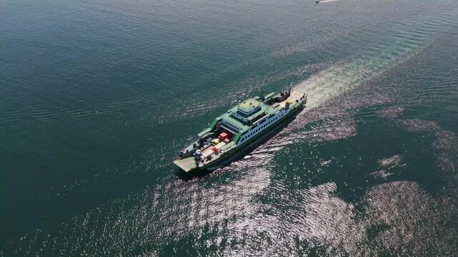 Orbiting drone shot of a Ro-Ro ship approaching Labuan Island port, Malaysia.