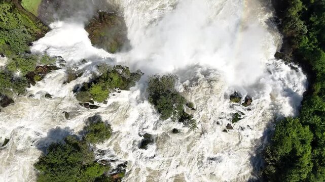 Drone top-down view of Binga Falls in Angola, showing the raw power of cascading water and mist surrounded by dense tropical forest in a remote African setting