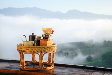 Drip coffee set on wooden table in morning with foggy background