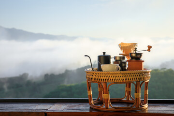 Drip coffee set on wooden table in morning with foggy background