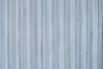 a light blue corrugated metal wall featuring uniform vertical lines, commonly used in industrial and commercial buildings.
