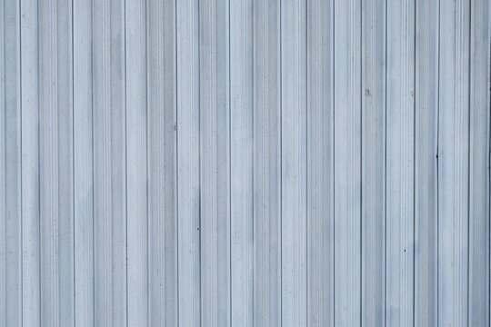 a light blue corrugated metal wall featuring uniform vertical lines, commonly used in industrial and commercial buildings.
