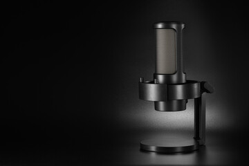 Black microphone with a desk stand on dark background with copy space.