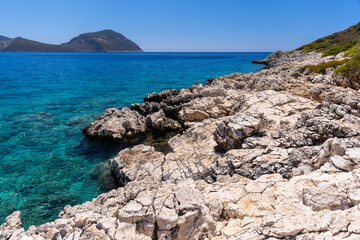 Wild beach Kalkan landscape photo. Turquoise waters lap a rugged rocky coast