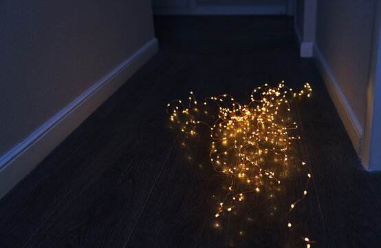Warm glowing fairy lights on a dark wooden floor