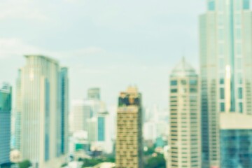 Obraz premium Blurred modern city skyline with towering skyscrapers under a bright sky