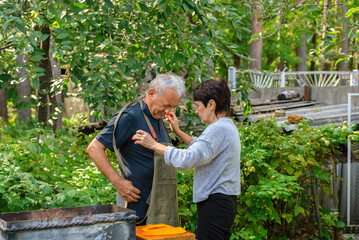 Couple preparing a barbecue in their garden