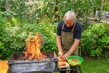 Man preparing a barbecue in a lush garden setting