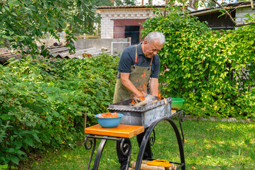 Man preparing a barbecue grill in the garden setting