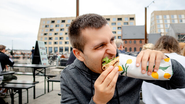 Man enjoying a burrito at Broens Gadekokken in Copenhagen