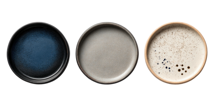 Three shallow, circular ceramic dishes in varying colors and textures