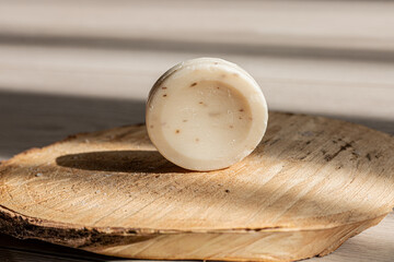 Handmade natural soap displayed on a wooden slice