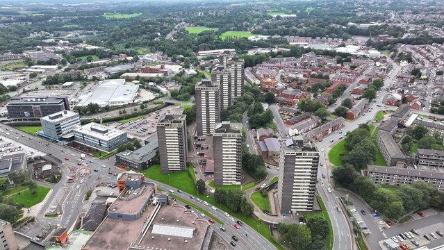Aerial view of College Bank Way's towering flats piercing the skyline amidst a tapestry of roads and buildings, Rochdale, England, United Kingdom.