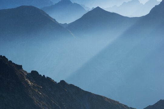 Aerial view from Jahnaci stit with sunlight cutting through the misty mountains, Vysoke Tatry, Presov Region, Slovakia.