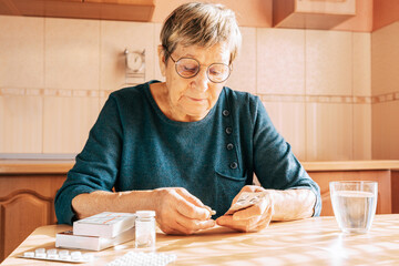 An elderly woman takes a large number of medications daily. Chronic disease treatment, aging, health problems, dementia and loneliness, home treatment, regular pill intake