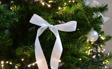 Elegant White Bow and Twinkling Lights on a Festive Greenery