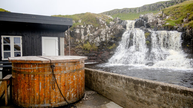 Rustic wood tub near Mykines waterfall scene