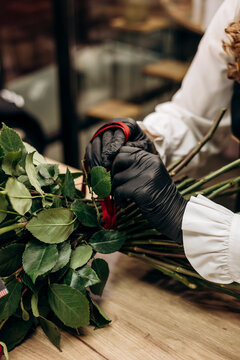 Florist arranging bouquet of vibrant red roses