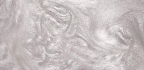 Shimmering silver abstract background. Liquid glitter paint texture waves and swirls. Beautiful shiny white glitter texture. Metallic silver paint close-up as a holiday background.